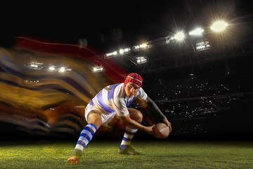 Image showing One caucasian man playing rugby on the stadium in mixed light