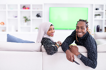 Image showing African Couple Sitting On Sofa Watching TV Together