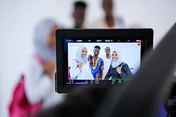 Image showing videographer in white studio recording video on professional cam