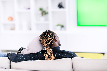 Image showing African Couple Sitting On Sofa Watching TV Together