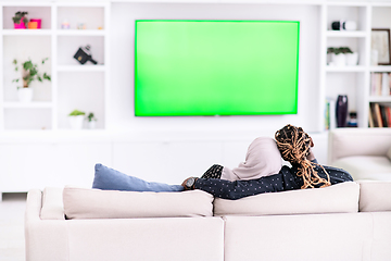 Image showing African Couple Sitting On Sofa Watching TV Together