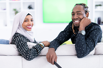 Image showing African Couple Sitting On Sofa Watching TV Together