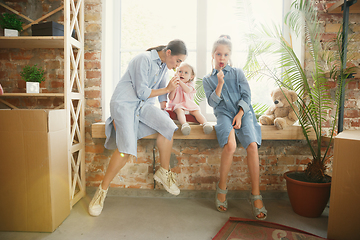 Image showing Young mother and her daughters moved to a new house or apartment