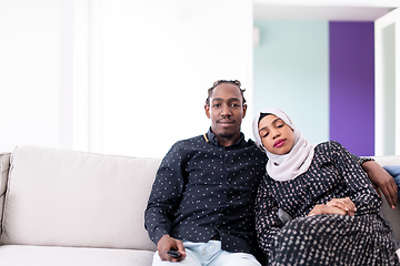 Image showing African Couple Sitting On Sofa Watching TV Together
