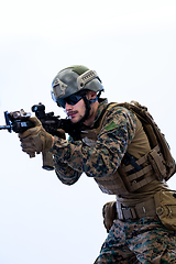 Image showing soldier in action aiming laseer sight optics