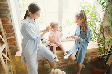 Image showing Young mother and her daughters moved to a new house or apartment