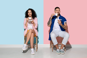 Image showing Young emotional man and woman on pink and blue background