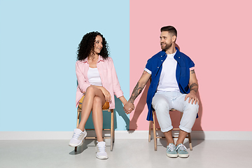 Image showing Young emotional man and woman on pink and blue background