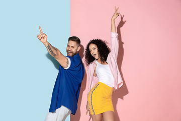 Image showing Young emotional man and woman on pink and blue background