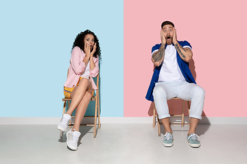 Image showing Young emotional man and woman on pink and blue background