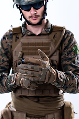 Image showing closeup of soldier hands putting protective battle gloves