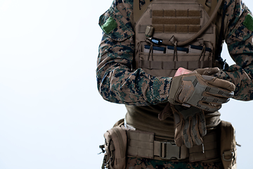 Image showing closeup of soldier hands putting protective battle gloves