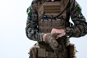 Image showing closeup of soldier hands putting protective battle gloves