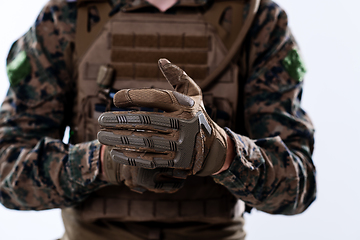 Image showing closeup of soldier hands putting protective battle gloves