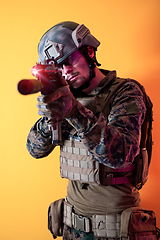 Image showing soldier in action aiming laseer sight optics yellow background