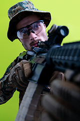 Image showing soldier in action aiming laseer sight optics green background