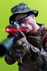 Image showing soldier in action aiming laseer sight optics green background