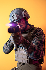 Image showing soldier in action aiming laseer sight optics yellow background