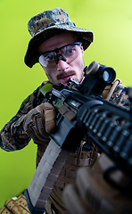 Image showing soldier in action aiming laseer sight optics green background