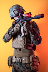 Image showing soldier in action aiming laseer sight optics yellow background