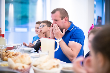 Image showing Eid Mubarak  Islamic family praying before halal Iftar dinner