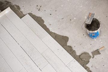 Image showing Ceramic wood effect tiles and tools for tiler on the floor