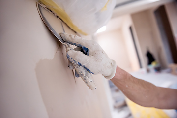 Image showing construction worker plastering on gypsum walls