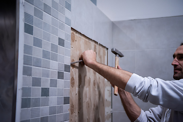 Image showing worker remove demolish old tiles in a bathroom