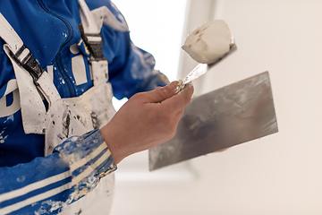 Image showing construction worker plastering on gypsum walls