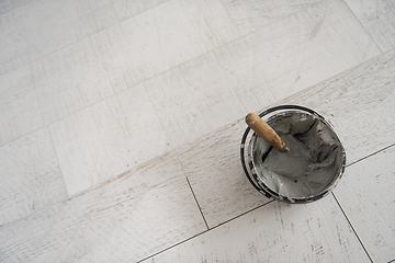 Image showing Ceramic wood effect tiles and tools for tiler on the floor