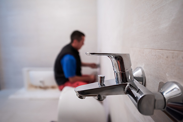 Image showing professional plumber working in a bathroom