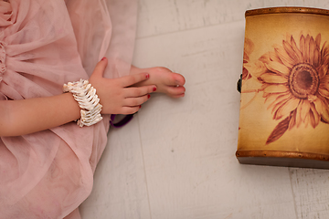 Image showing little girl enjoying while playing with mother\'s jewelry