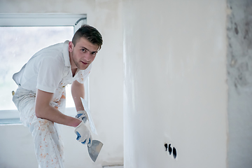 Image showing construction worker plastering on gypsum walls