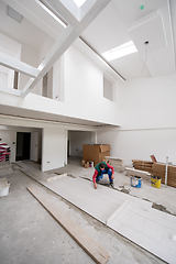 Image showing worker installing the ceramic wood effect tiles on the floor