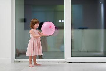 Image showing cute little girl playing with balloons