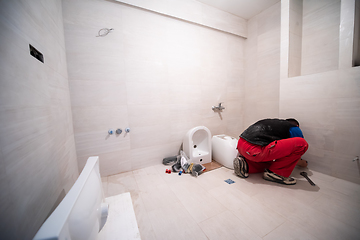 Image showing professional plumber working in a bathroom