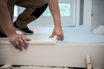 Image showing Worker Installing New Laminated Wooden Floor