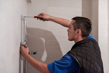 Image showing professional plumber working in a bathroom