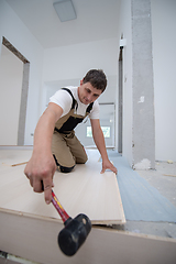 Image showing Professional Worker Installing New Laminated Wooden Floor