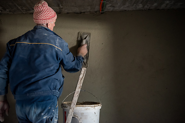 Image showing Worker plastering the wall by concrete