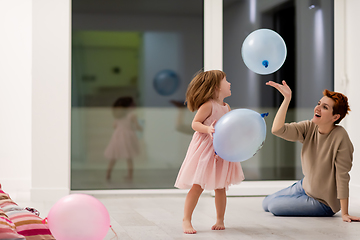 Image showing mother and cute little daughter playing with balloons