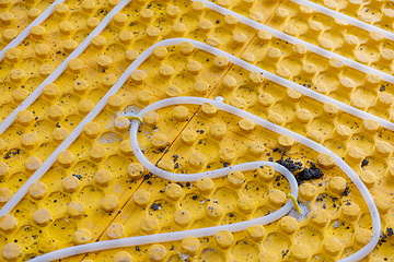 Image showing yellow underfloor heating installation with white pipes