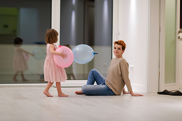 Image showing mother and cute little daughter playing with balloons