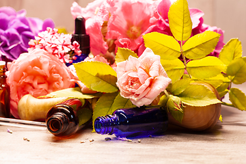 Image showing flowers and bottles of essential oils for aromatherapy