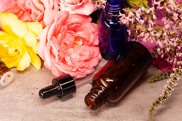 Image showing flowers and bottles of essential oils for aromatherapy