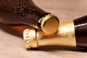 Image showing a bottle of blonde beer and a bottle of amber beer lying down