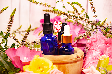 Image showing flowers and bottles of essential oils for aromatherapy