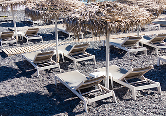 Image showing beach with umbrellas and deck chairs by the sea in Santorini