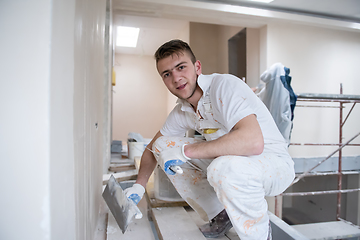 Image showing construction worker plastering on gypsum walls