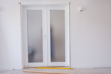 Image showing carpenters installing glass door with a wooden frame